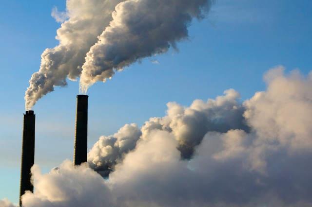 Gas emissions are seen entering the atmosphere from a factory's smokestacks.