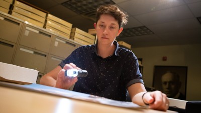 An I P I employee shines a light on a specimen to examine it.