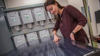 Woman with her hands on a photovoltaic panel.