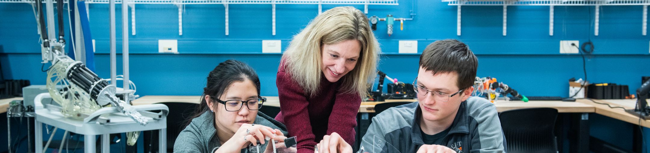 Students working with a professor in a lab