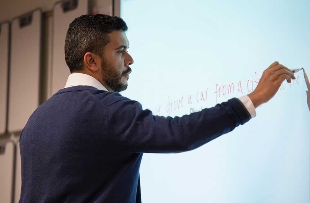 Instructor writing on a whiteboard during a classroom lesson.