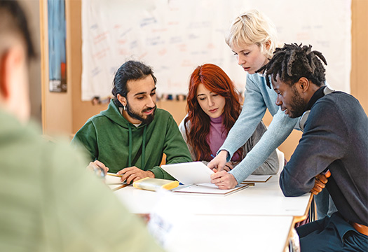Group of diverse college students working together on a project in a classroom setting - Teamwork, diversity, and collaboration, with students engaged in discussion and study activities.