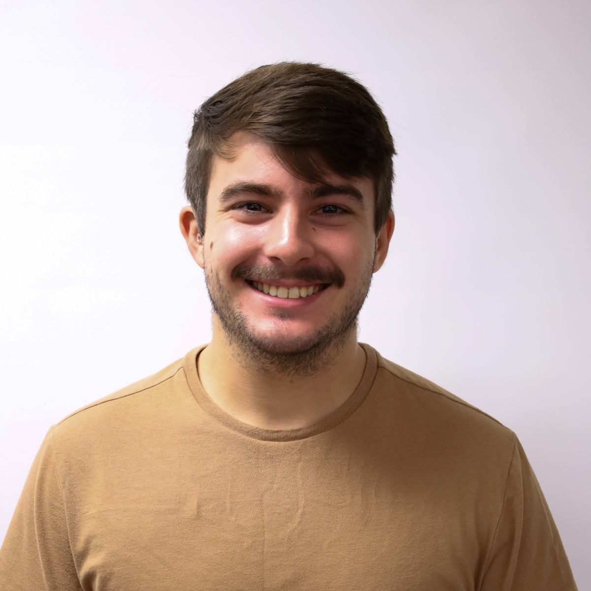 A young man with brown hair smiling.