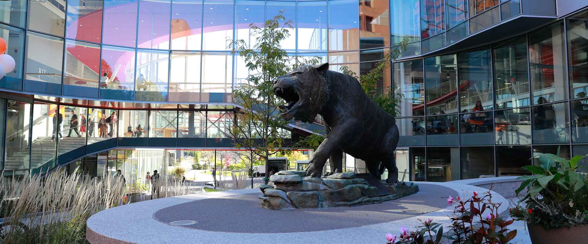 the tiger statue with a glass building in the background.