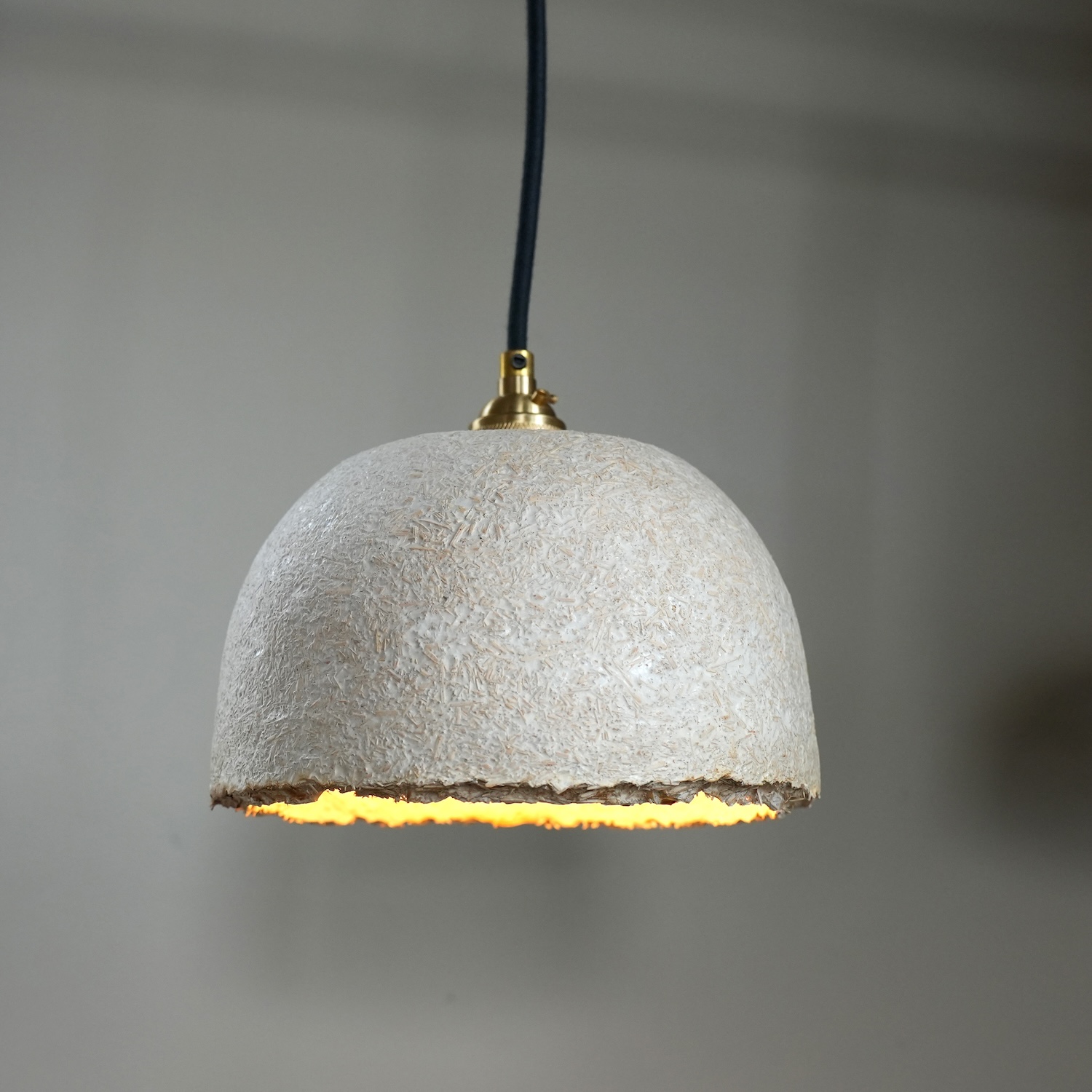 a white pendant lamp with a textured surface.