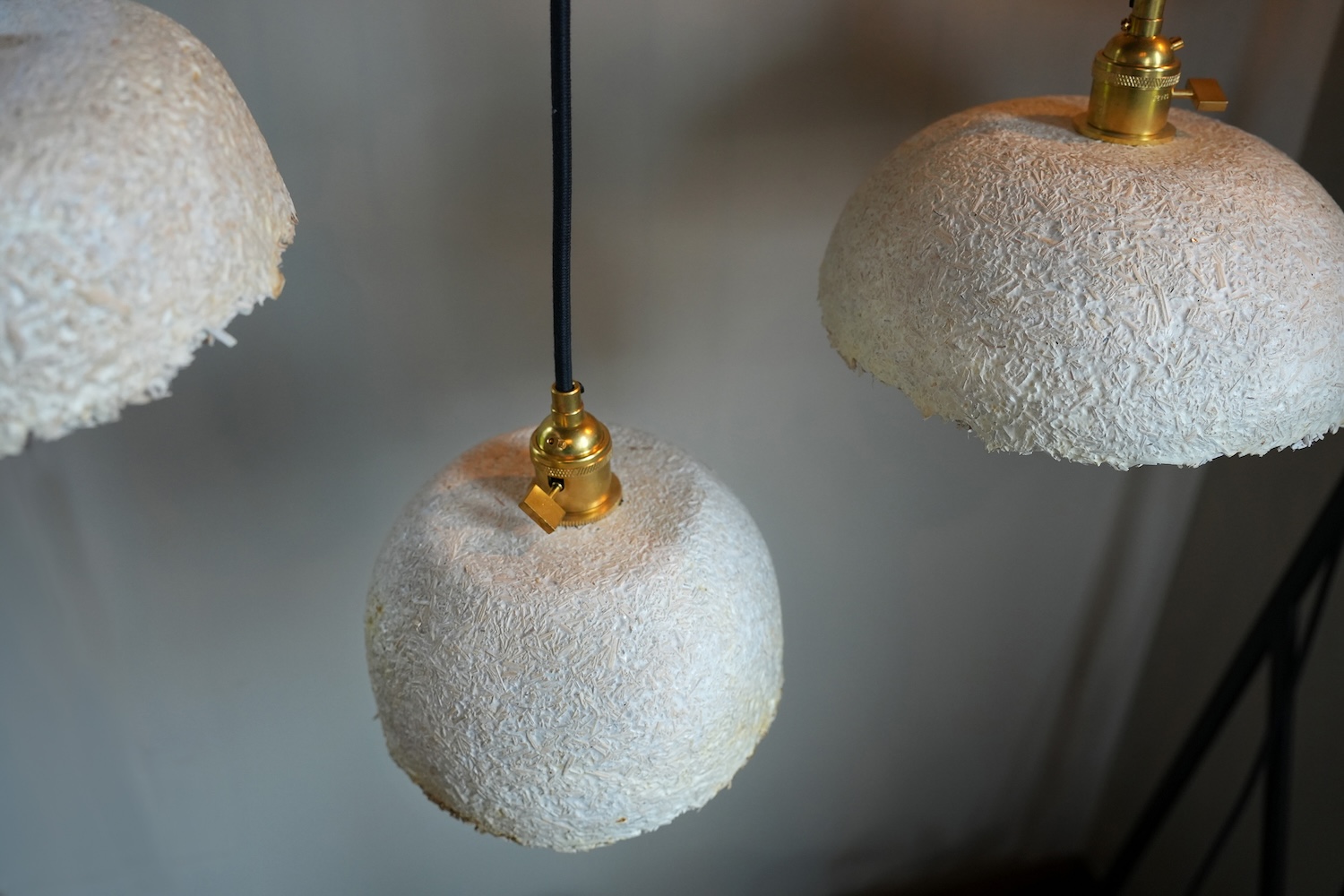 a close up of three pendant lamps with a textured surface.