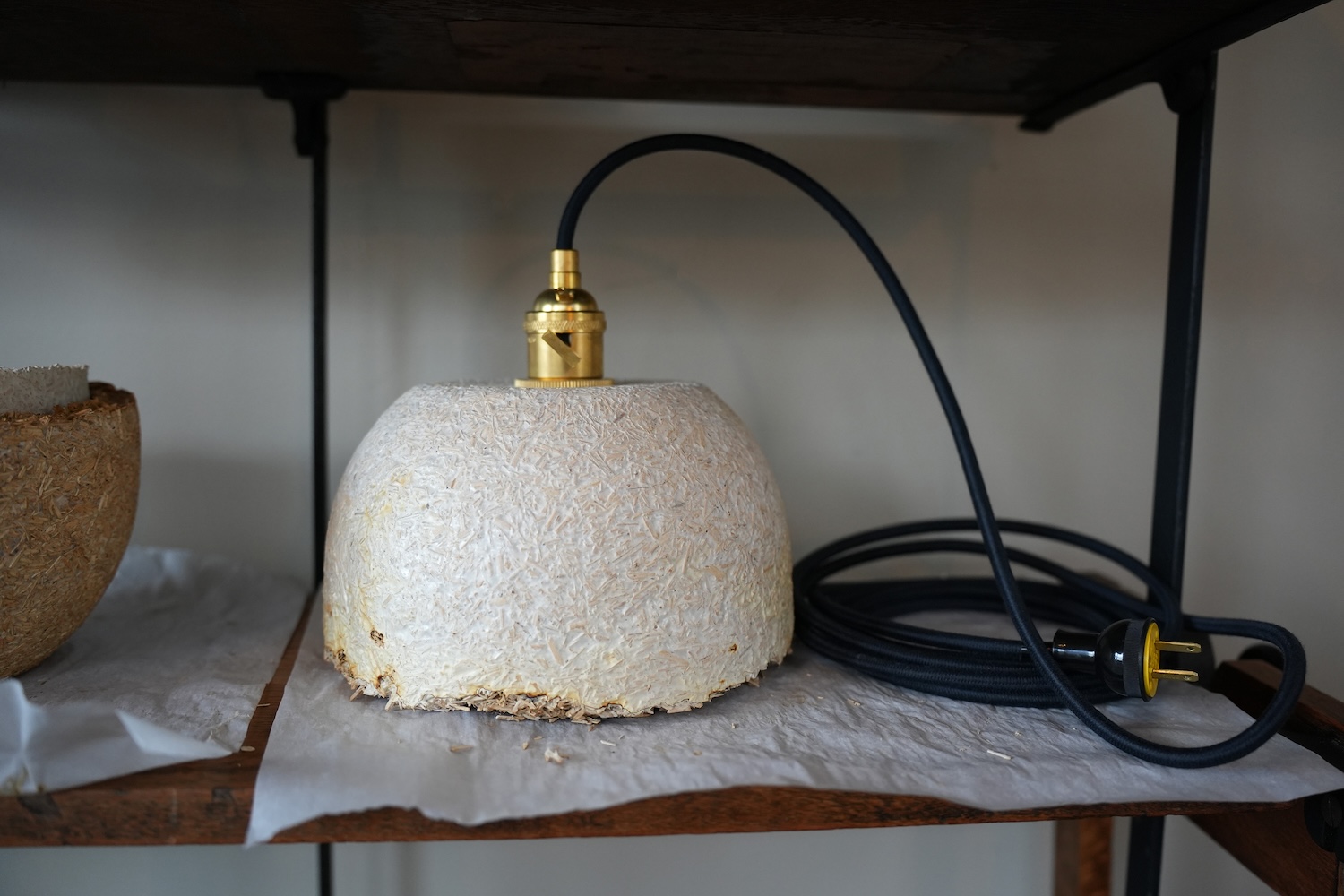 a close up of a pendant lamp with a textured surface placed on a shelf.
