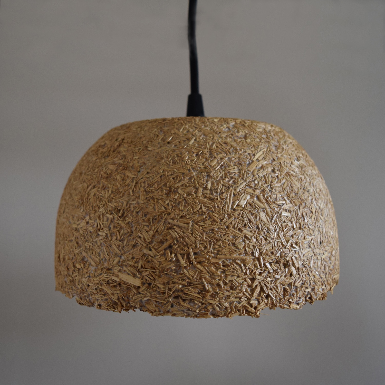 a light brown pendant lamp with a textured surface.