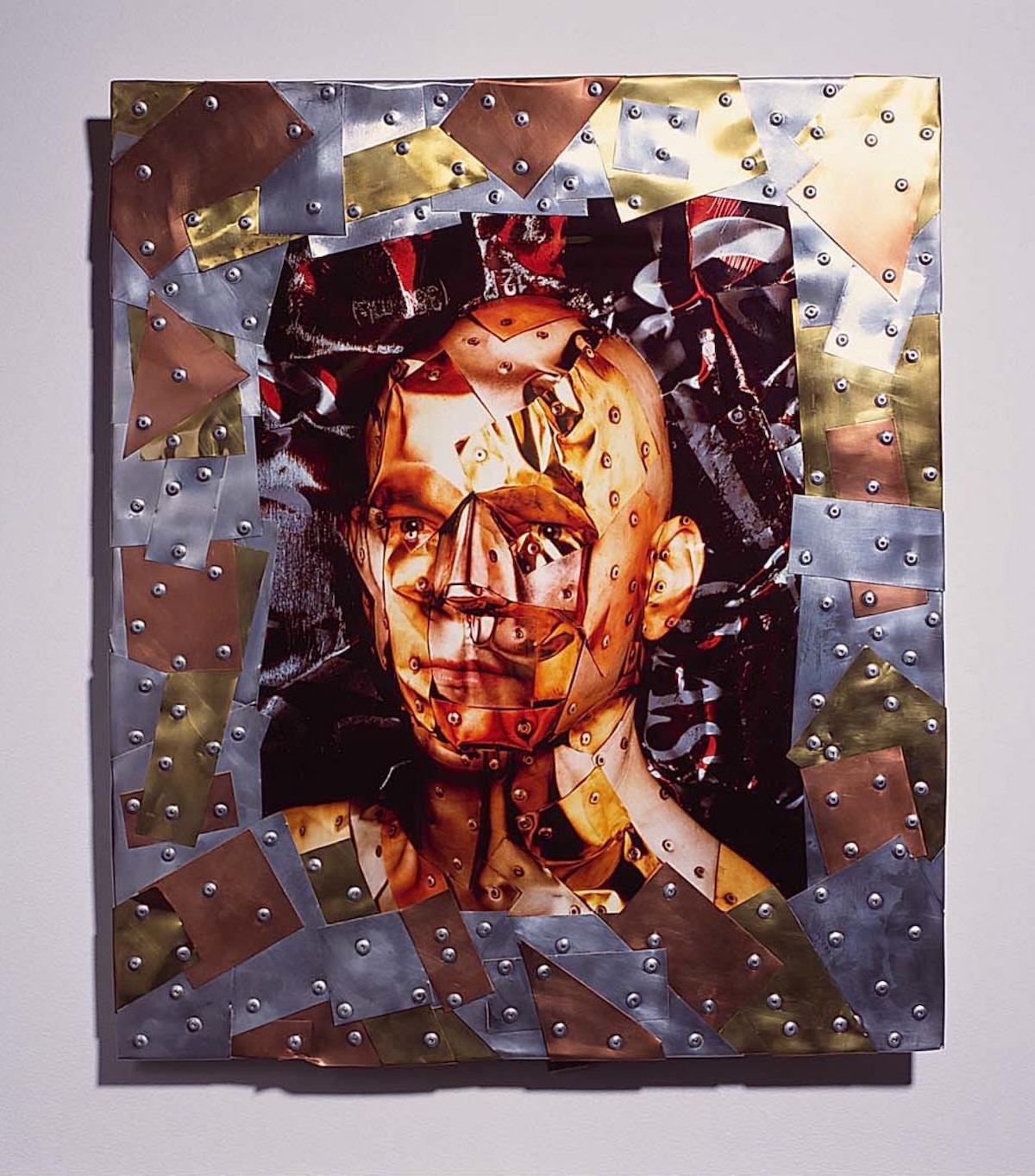 an image of a face that has been illustrated with a layering of riveted metal pieces that subtly create an abstracted face.