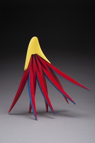 Carved wood form with multiple tendril shaped legs painted in red, blue and yellow
