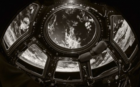 View of Earth from inside the space station cupola gridded windows. Black and white.