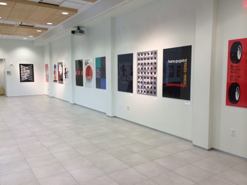 View of gallery installation with multiple posters on the walls.