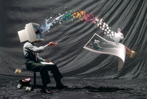 Manipulated photographic image of a seated man with a computer for a head with a rainbow of color and rabbits streaming out of the screen.