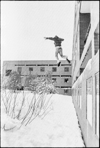Person jumping out of a second story lounge in a dorm into a huge snow bank