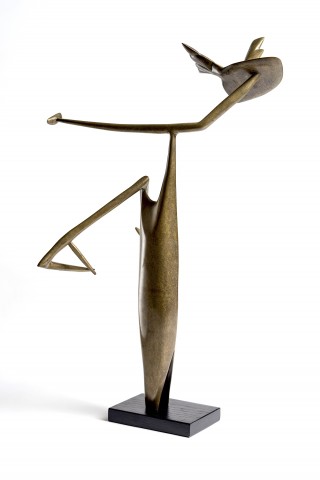 Bronze standing sculpture with a smooth trunk like form with an arm like protrusion and swooping branch and bird form above