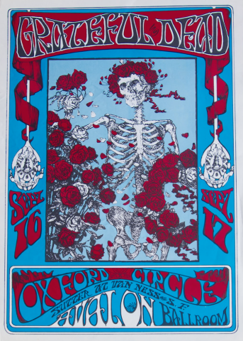 a poster with a sky blue background with the words 'Grateful Dead' printed in a stylistic font above an image of a skeleton surrounded by red roses. 