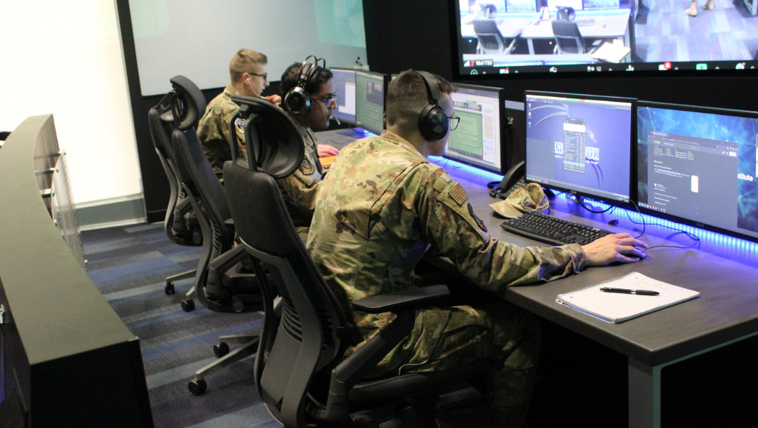 People in military uniform using computers