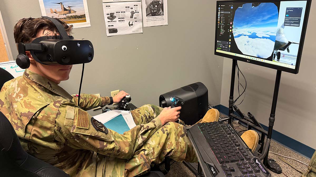 an Air Force R O T C cadet wears a V R headset while using a flight simulator computer program.