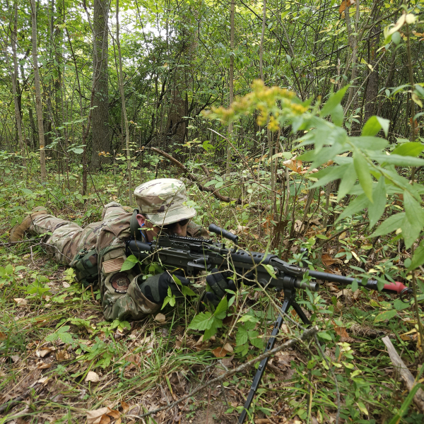 Cadet Hutson in camo laying in the forest