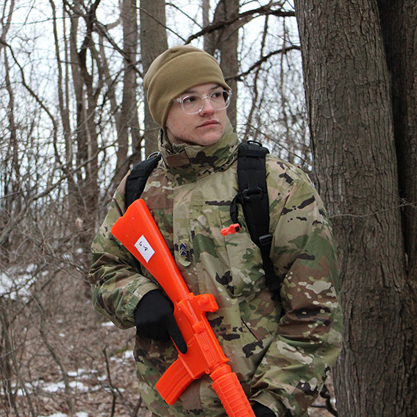 Cadet Andrew Lerma outdoors with a training rifle.