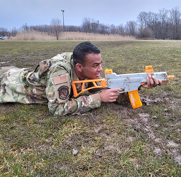 Cadet Srivatsha Nammalvar on the ground with a training firearm.