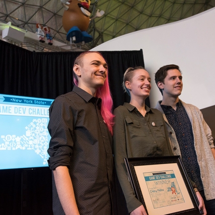 Three students holding the Game Dev Challenge award certificate.