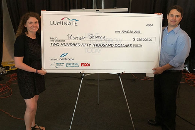 Two people holding large check.