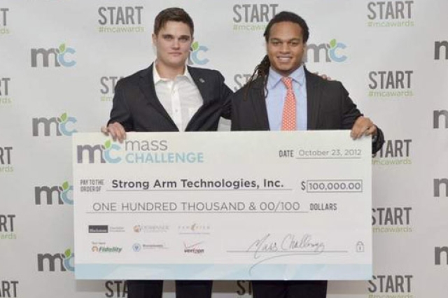 Two people posing with giant check