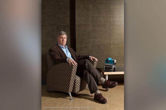 Picture of person sitting in chair next to camera