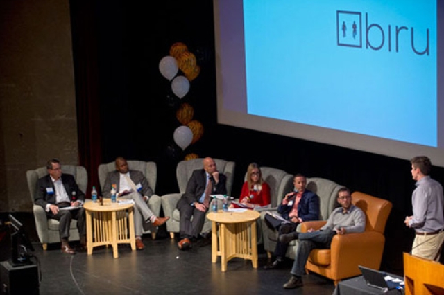 People sitting on chairs on stage