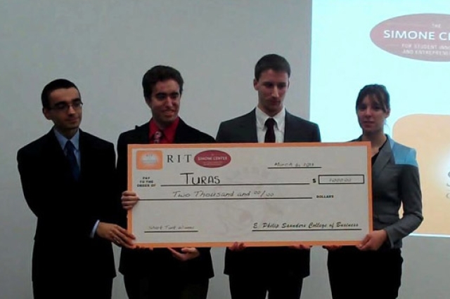 People posing with large check