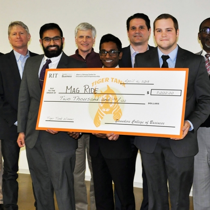 Students, faculty and staff hold giant check.
