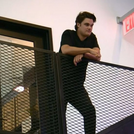 Man stands at top of stairwell.