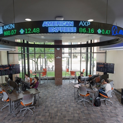 open lab with two computer workstations and digital stock ticker.