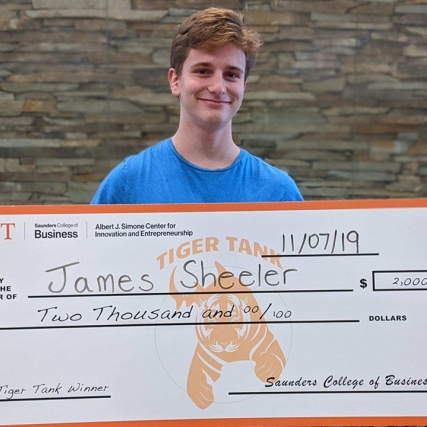 James Sheeler holds the giant $2,000 check he was awarded for winning the Tiger Tank competition.