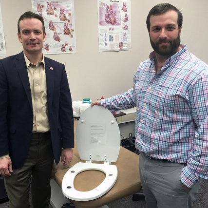 researcher and professor with toilet seat embedded with sensors.