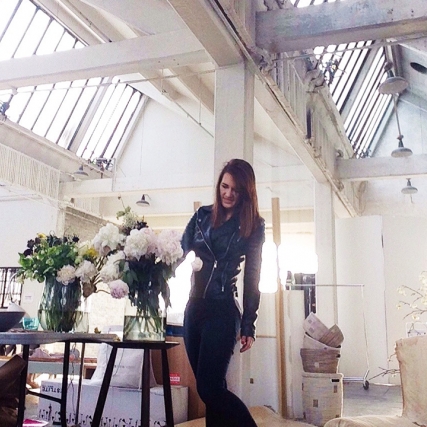 Michelle Bablitz adjusts flowers on the table of a photo shoot set.
