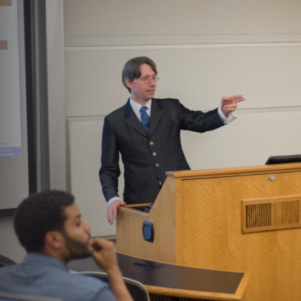 A Saunders professor teaches his class in a learning hall.