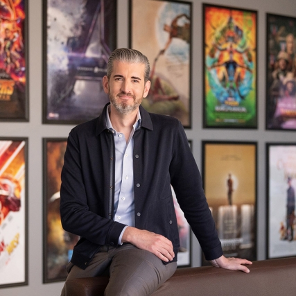 person posing in front of movie posters.