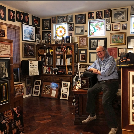 man sitting in office full of photos of celebrities.