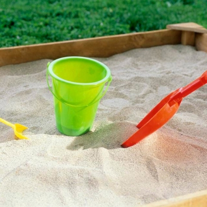 children's sandbox with a pail and two shovels.