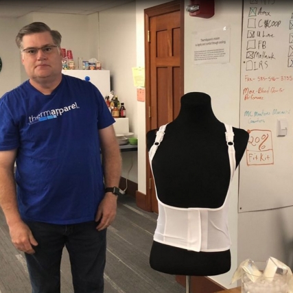 man standing next to a mannequin wearing a cooling vest.