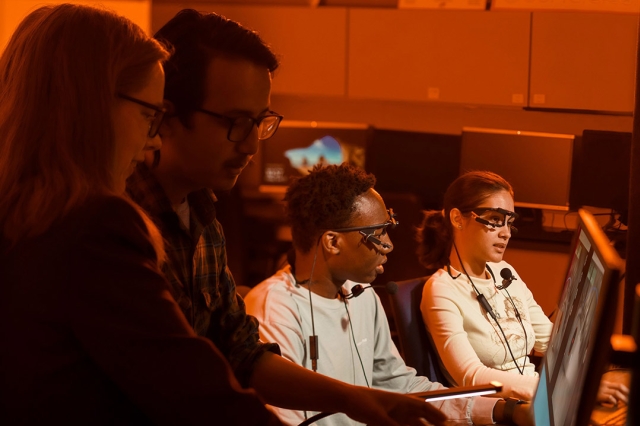 researchers wearing head sets and eye-tracking glasses.