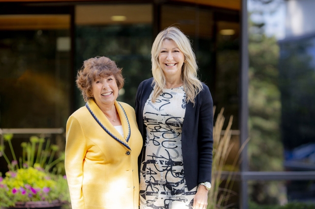 mother and daughter posing for a photo side by side.