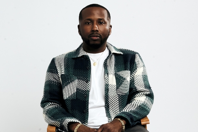 RIT alumnus Randall Yarborough, well-known footwear designer at Adidas and apparel designer for many brands, sits in a chair.