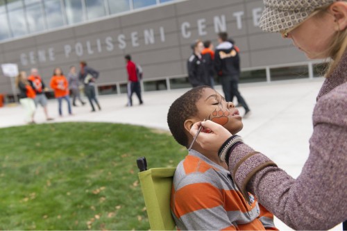 a kid getting his face painted outside at an RIT event