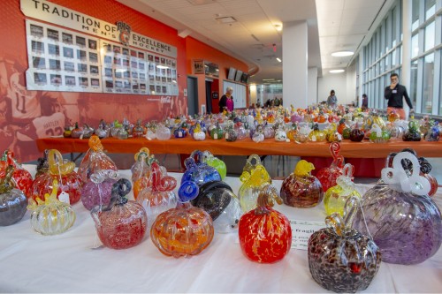 a table full of glass pumpkins for sale