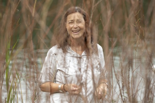 someone smiling in a lake through tall grass