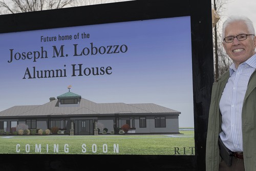 Joseph Lobozzo with sign for new Alumni House