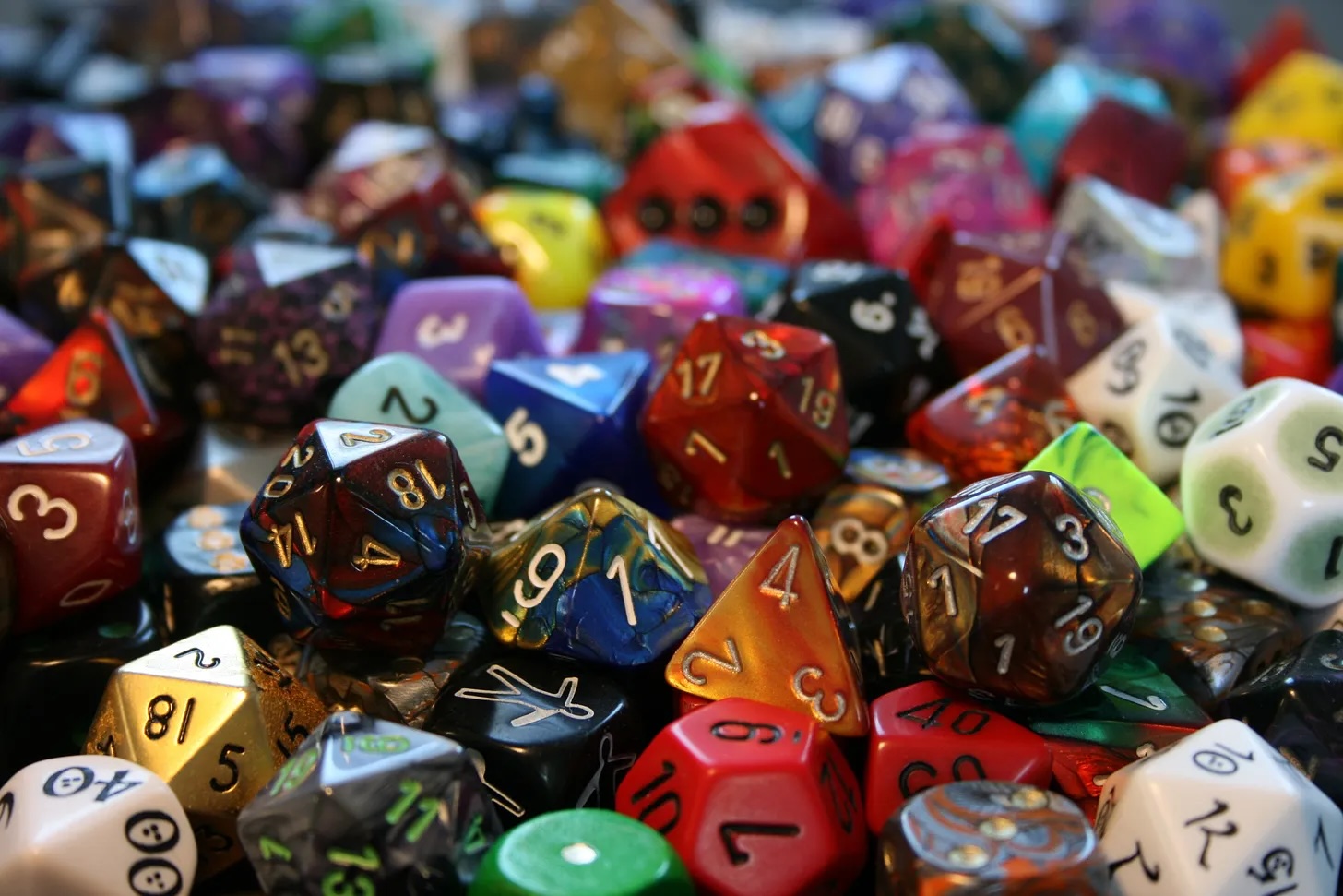 A collection of colorful polyhedral gaming dice scattered together on a tabletop.
